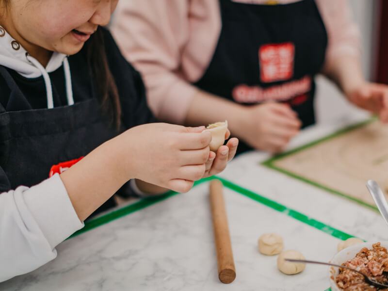 A person making dim sum at a cooking class in London.
